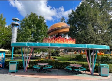 Giant hamburger display over fake fire on top of a patio eating area