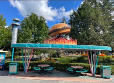 パティオのイートインスペースの上に、フェイクファイヤーで巨大なハンバーガーをディスプレイ。